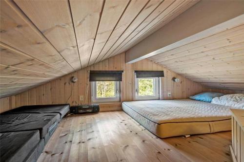 a bedroom with two beds in a room with wooden walls at C11148-Hemmet-Lappedykkervaenget-22 in Hemmet
