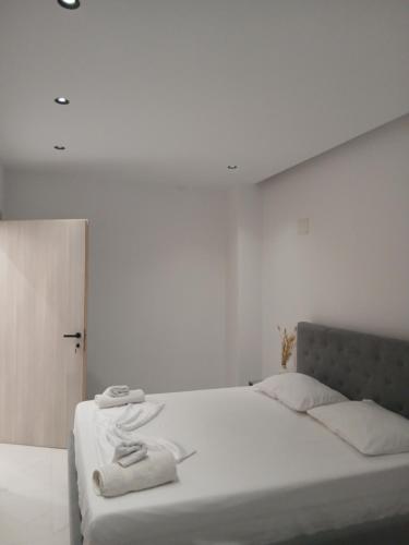 une chambre blanche avec un lit avec des serviettes dessus dans l'établissement Sela Apartaments, à Ksamil