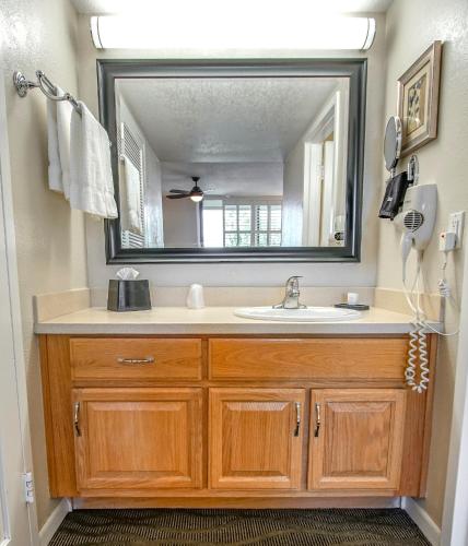 a bathroom with a sink and a large mirror at Palm Springs Tennis Club in Palm Springs