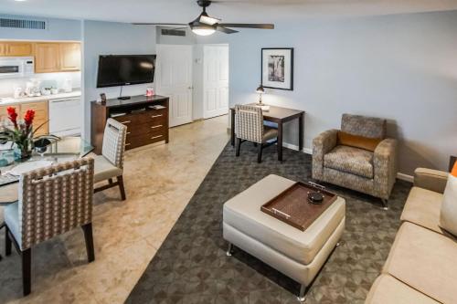 a living room with a couch and a dining room at Palm Springs Tennis Club in Palm Springs