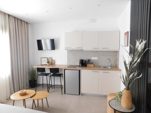 a kitchen with white cabinets and tables and chairs at Cozy Studio with Patio - Walk to City Center in Bendevís