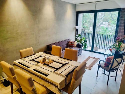 a dining room with a wooden table and chairs at Yu Country GDL 1parking 2BR 2BA in Guadalajara