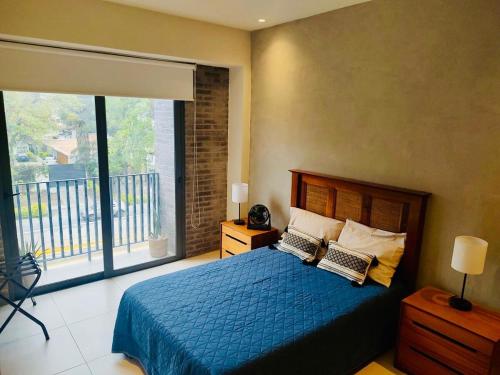 a bedroom with a blue bed and a large window at Yu Country GDL 1parking 2BR 2BA in Guadalajara