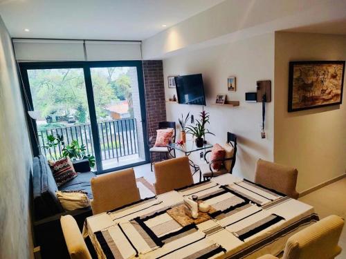 a living room with a table and chairs and a balcony at Yu Country GDL 1parking 2BR 2BA in Guadalajara