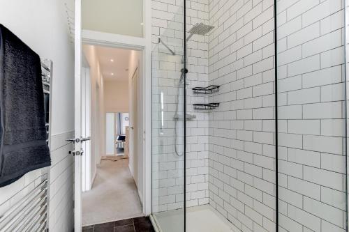 a bathroom with a shower with white subway tiles at Charming Coastal Retreat in BN2 in Brighton & Hove