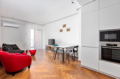 a living room with a red chair and a table at Tbilisi Hilton Apartment in Tbilisi City