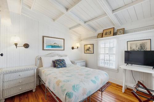 una camera da letto con un letto e una TV a schermo piatto di Sunny oceanfront home with balcony, full kitchen, central AC, & washer/dryer a Summer Haven