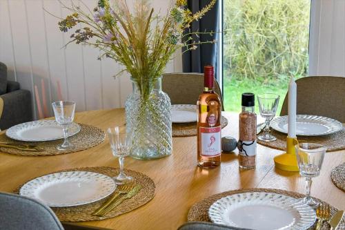 a wooden table with plates and wine bottles on it at C11593-Hemmet-Bork-Hytteby-98 in Hemmet