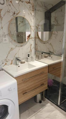 a bathroom with two sinks and a washing machine at Charmant appartement avec jardin in Figeac