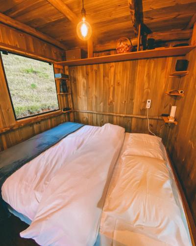 a bed in the inside of a wooden cabin at Valle - Cabanas & Chalés Villaggio Girotto in Marmelopolis