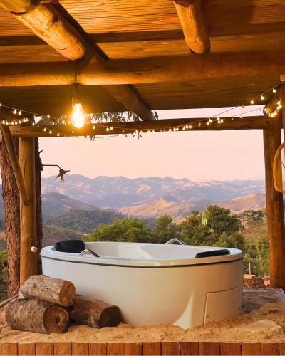 a bath tub in a cabin with a mountain view at Valle - Cabanas & Chalés Villaggio Girotto in Marmelopolis