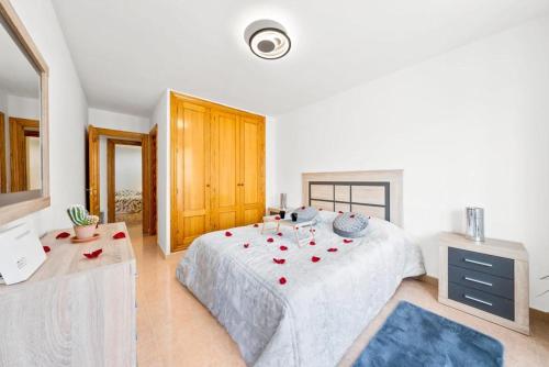 a bedroom with a large bed with red roses on it at Apartamento confortable en Altea in Altea