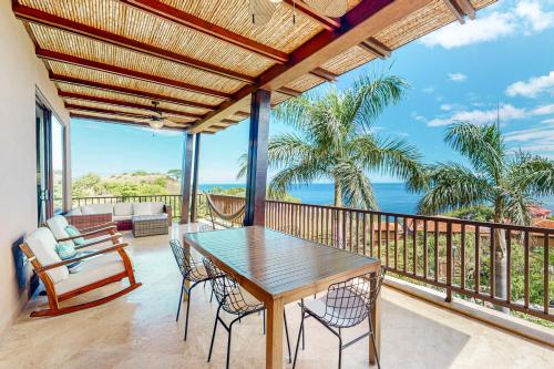 a dining room with a table and chairs on a balcony at Azul Paraiso 7B in Coco
