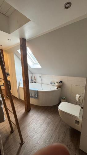 a bathroom with a bath tub and a toilet at Cottage - Kleine alte Villa am See in Bestensee