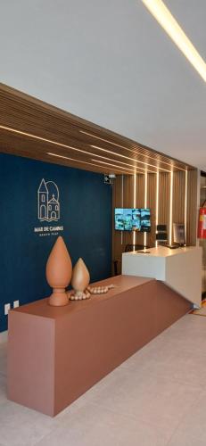 a lobby with a table and a blue wall at Flat Mar de Campas Beach Tamandaré in Tamandaré