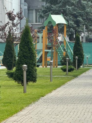 a park with a playground with trees and a slide at Апартаменти новобудова Львів in Lviv