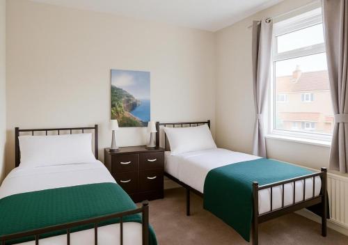 two beds in a room with a window at Spacious 3-Bed Contractor-Friendly Home in Bristol