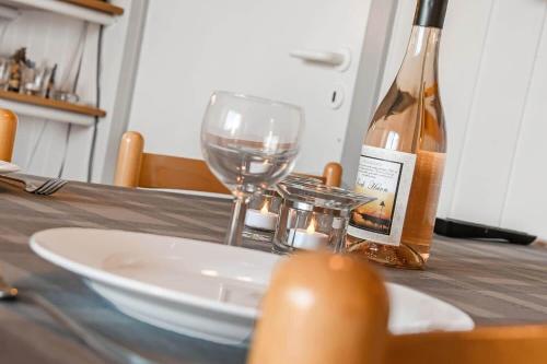 una mesa con una botella de vino y una copa en C11567-Hemmet-Kirkehojvej-36-S3, en Hemmet