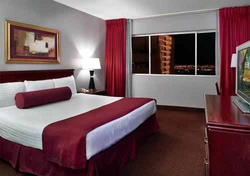 a hotel room with a large bed and a window at Four Queens Hotel and Casino in Las Vegas