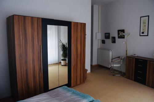 a bedroom with a large wooden closet with a mirror at Ferienappartment in der City in Bremen