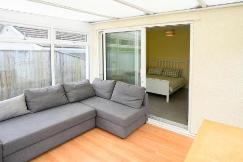 a living room with a couch and a bedroom at Rhianfa Manorbier in Manorbier