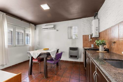 a small kitchen with a table and purple chairs at El Puerto - Cerca de todo in Cordoba