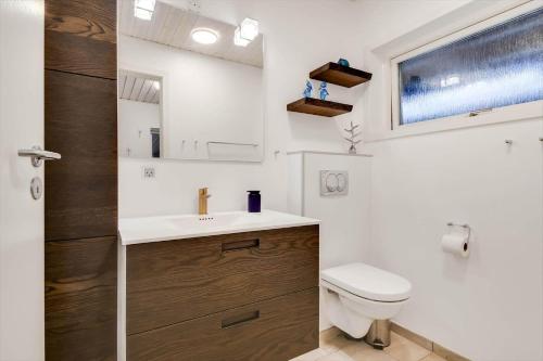 a bathroom with a toilet and a sink and a mirror at C11253-Hemmet-Skuldbolvej-7-b in Hemmet