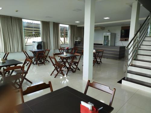 una sala da pranzo con tavoli e sedie e una cucina di Tradicional Plaza Hotel a Nerópolis