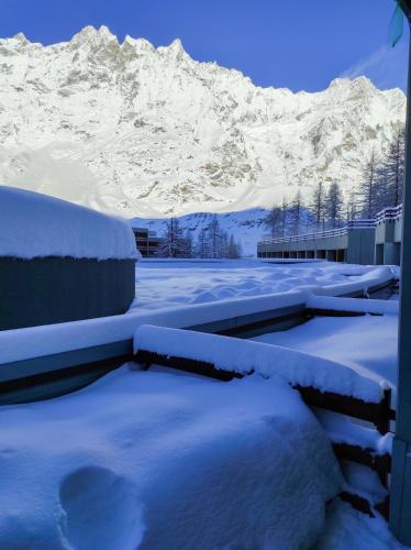 a snow covered building with a mountain in the background at Mountain Studio 109A in Breuil-Cervinia