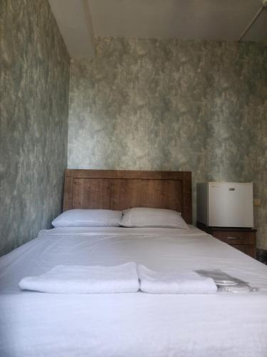 a bed with white sheets and pillows in a bedroom at Kavela555 in Tbilisi City