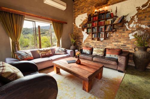a living room with couches and a brick wall at Wolfkop Nature Reserve in Citrusdal