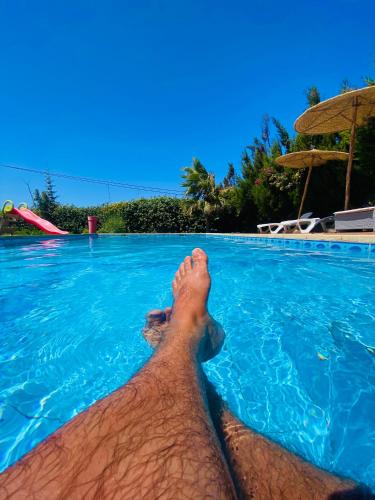 a man laying in a swimming pool with his foot in the water at Villa Sunset Moulay Bouzerktoun in Essaouira