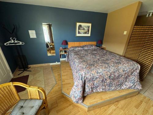 a bedroom with a bed and a chair at Auberg & Motel Moka Creme in Lévis