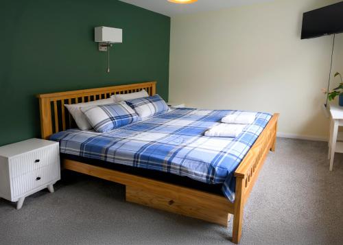 a bedroom with a bed with a blue and white plaid at Rhianfa Manorbier in Manorbier