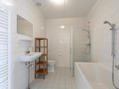 a bathroom with a sink and a tub and a toilet at Apartment near Groote Keeten Beach in Groote Keeten