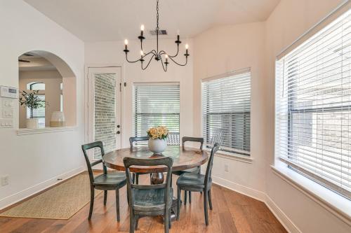 a dining room with a table and chairs and windows at Heated Pool Family-Friendly Houston Area Home! in Manvel