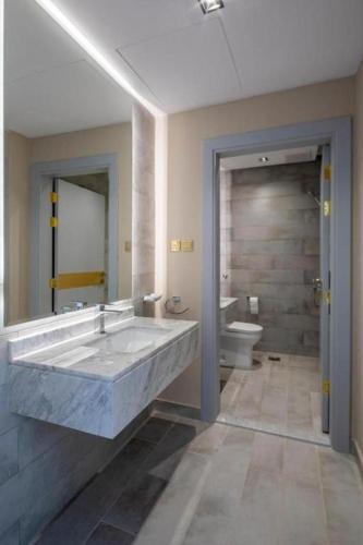 a bathroom with a large marble sink and a toilet at كيونا للأجنحة والفلل - Kyona suites & villas in Jeddah