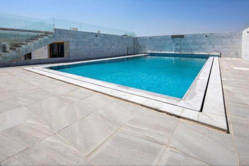 a large swimming pool with blue water in a building at كيونا للأجنحة والفلل - Kyona suites & villas in Jeddah