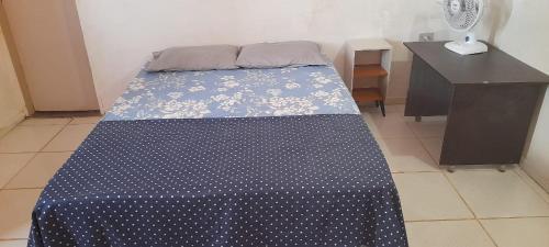 a bed in a room with a blue and white comforter at Hostel da Lua in Barreirinhas