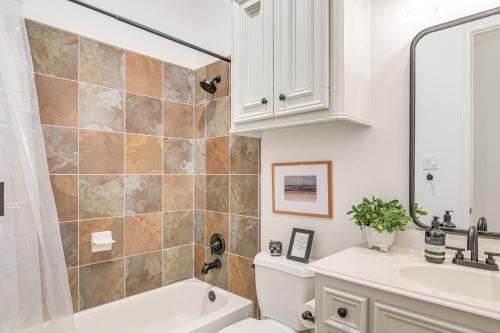 a bathroom with a sink and a tub and a toilet at Heated Pool Family-Friendly Houston Area Home! in Manvel