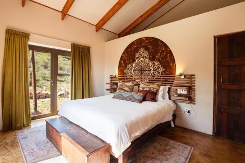 a bedroom with a large bed with a wooden headboard at Wolfkop Nature Reserve in Citrusdal