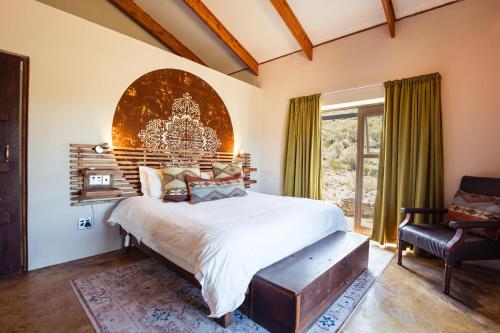 a bedroom with a large bed and a chair at Wolfkop Nature Reserve in Citrusdal