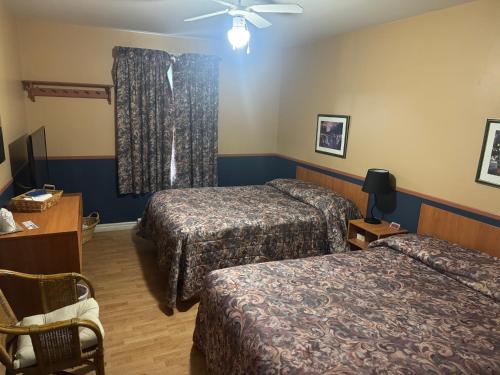 a hotel room with two beds and a ceiling fan at Auberg & Motel Moka Creme in Lévis