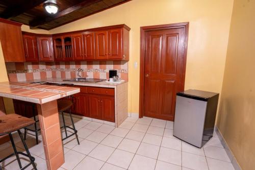 a kitchen with wooden cabinets and a small refrigerator at Best Western Las Mercedes Airport in Managua