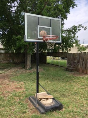 a basketball hoop with a basket in a yard at Explore Austin & San Antonio with friends & family in Kyle