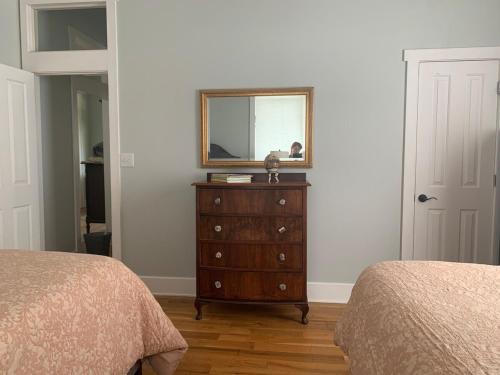 a bedroom with two beds and a dresser with a mirror at Explore Austin & San Antonio with friends & family in Kyle