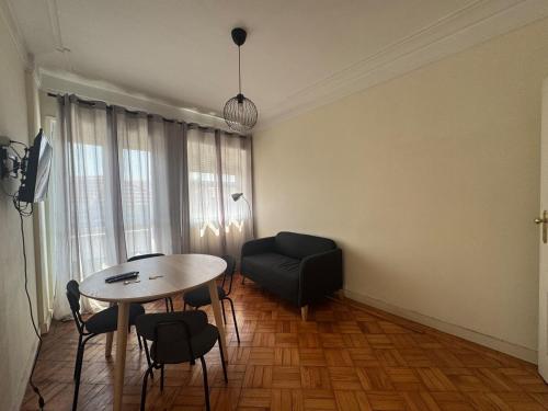 a living room with a table and a chair at Lumiére Cedofeita in Bicas