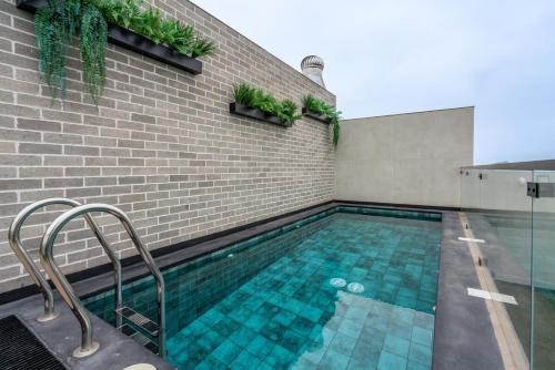 La Mar by Geko في ليما: مسبح وبلاط اخضر في مبنى