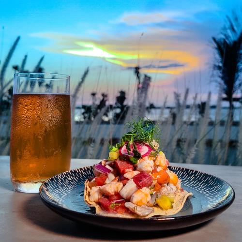 a plate of food next to a glass of beer at InHouse Glamping Hotel La Paz in La Paz