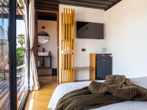 a bedroom with a bed and a tv on the wall at InHouse Glamping Hotel La Paz in La Paz